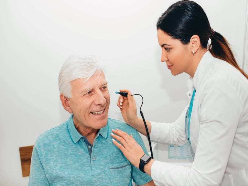 Audiologist visiting a patient at home